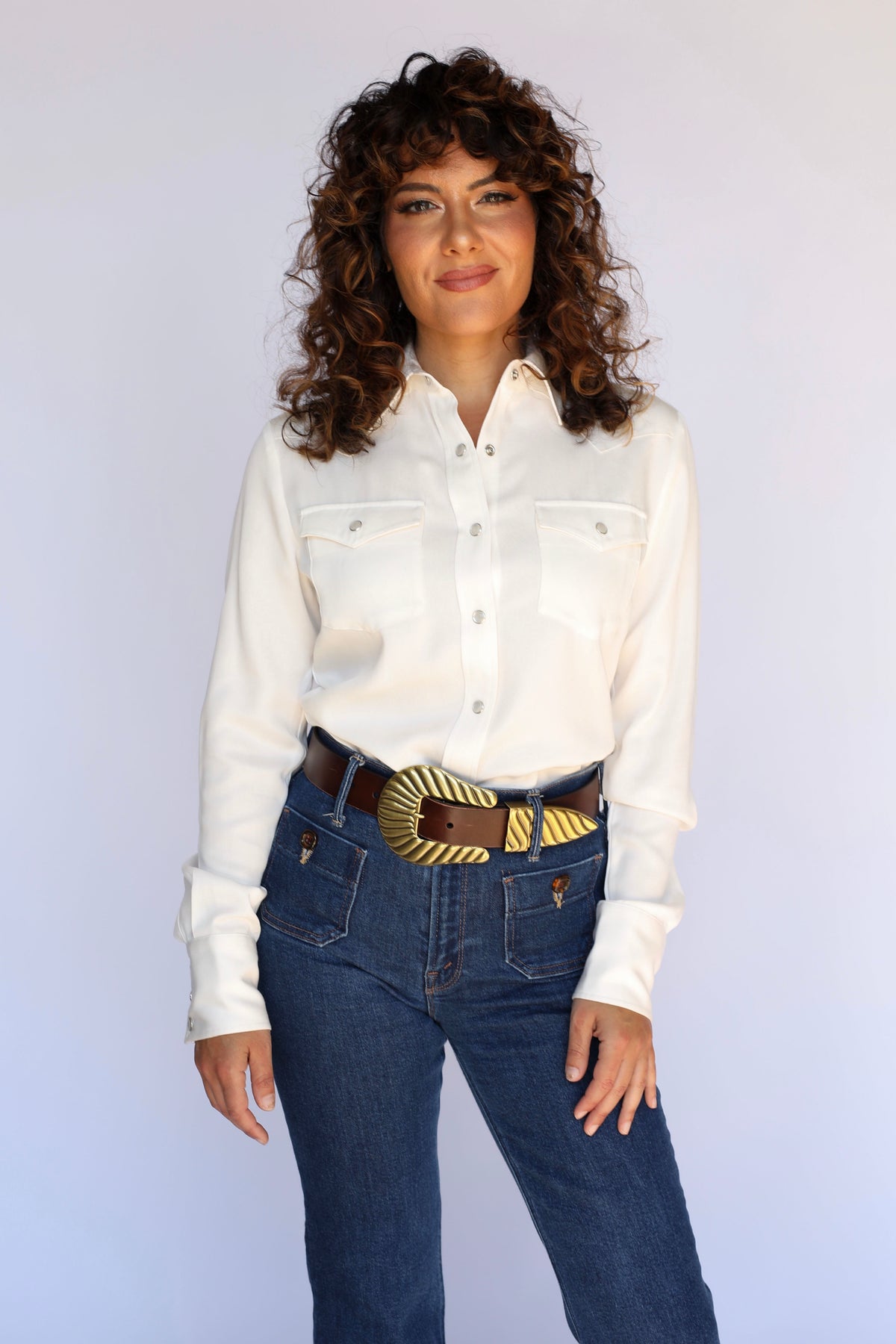 Woman wearing the H Bar C Denver women's white western snap shirt tucked into dark jeans with a gold buckle, classic vintage inspired western wear.