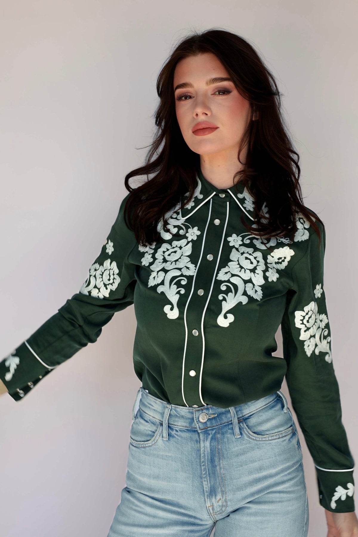 Woman in green shirt with floral embroidery