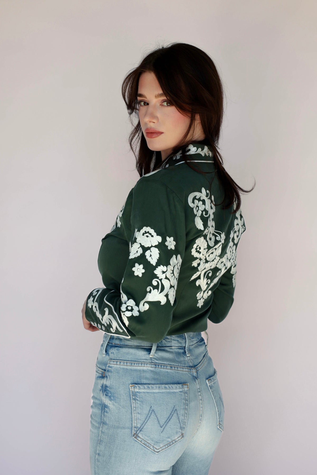 Woman in green shirt with floral embroidery