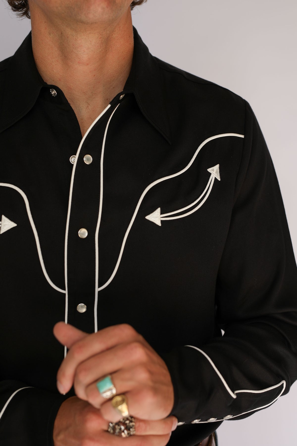 Close-up of the H Bar C San Fernando black shirt yoke with white piping and embroidered arrows, vintage western wear detail.