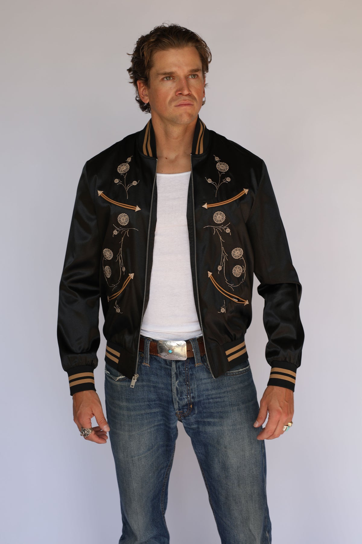 Full length view of the H Bar C x Gibson J-200 Odessa black jacket worn open with jeans, vintage inspired western wear.