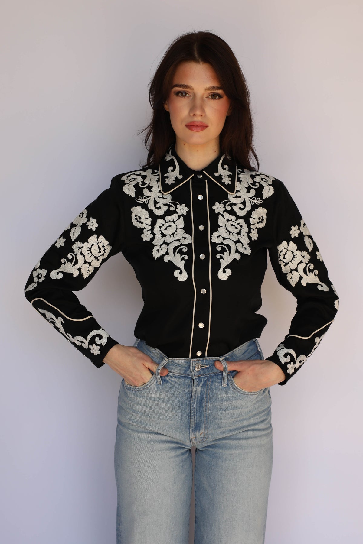 Woman wearing the H Bar C Fort Worth black shirt with embroidered cuffs and piping, vintage inspired western wear.