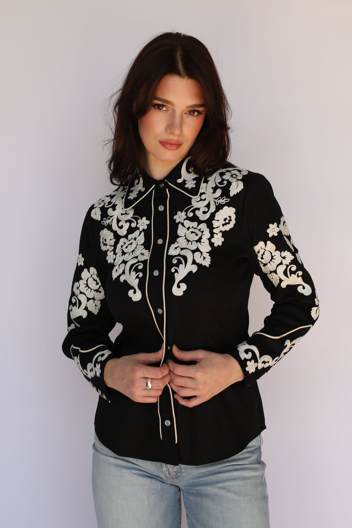 Woman wearing the H Bar C Fort Worth women's black western shirt with ivory chain stitch floral embroidery and piping, vintage inspired western wear.