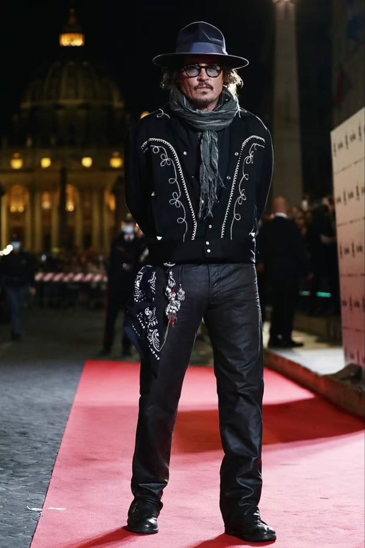 Person in stylish outfit with embellishments on a red carpet event.