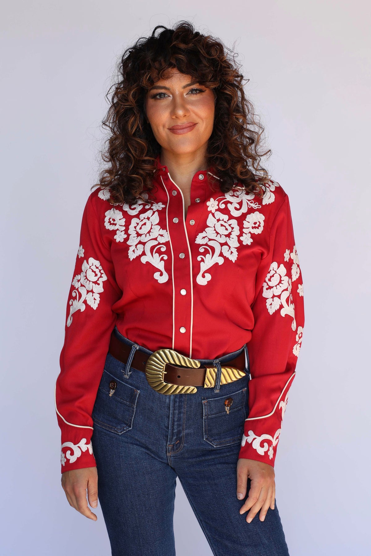 Woman wearing the H Bar C Fort Worth women's red western shirt with cream chain stitch floral embroidery and piping, vintage inspired western wear.