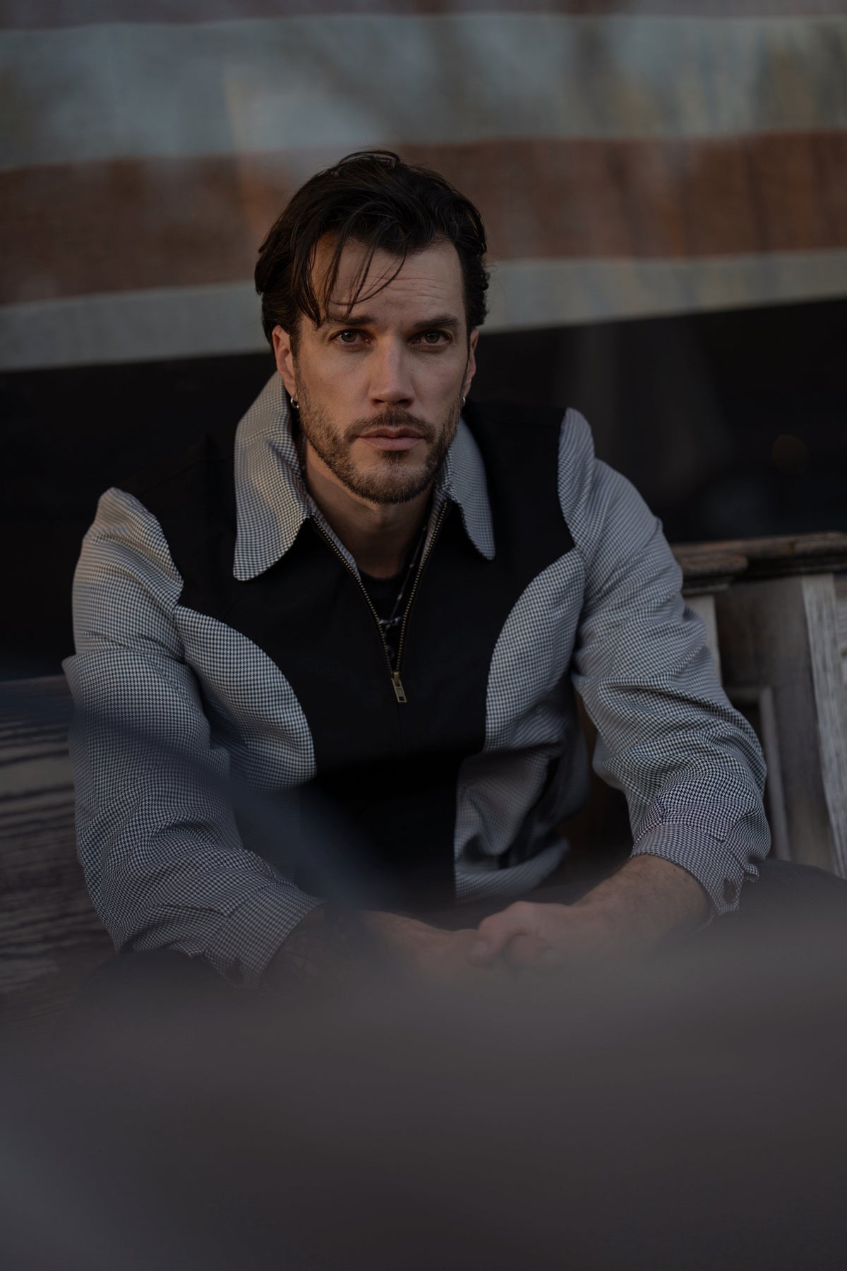 Man sitting on a wooden bench with a blurred background