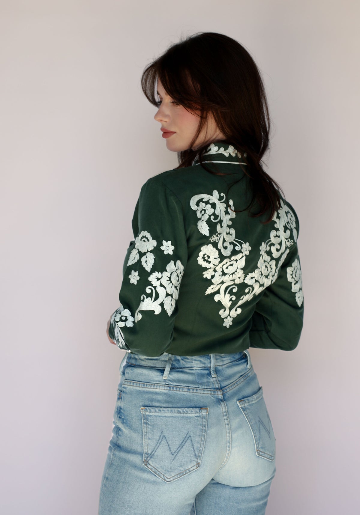 Woman in green shirt with floral embroidery