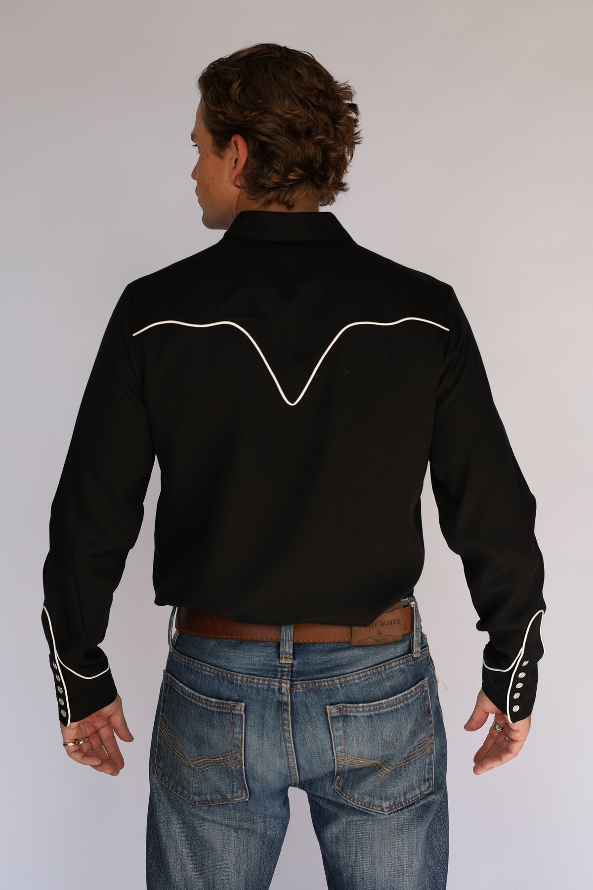 Three-quarter back view of the H Bar C San Fernando black western shirt, vintage inspired western wear with white piped back yoke.