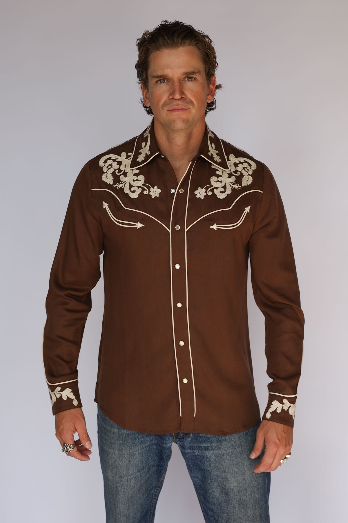 Man wearing the H Bar C Durango brown shirt, vintage inspired western wear with cream embroidery, pearl snaps, and rodeo cuffs, front view.