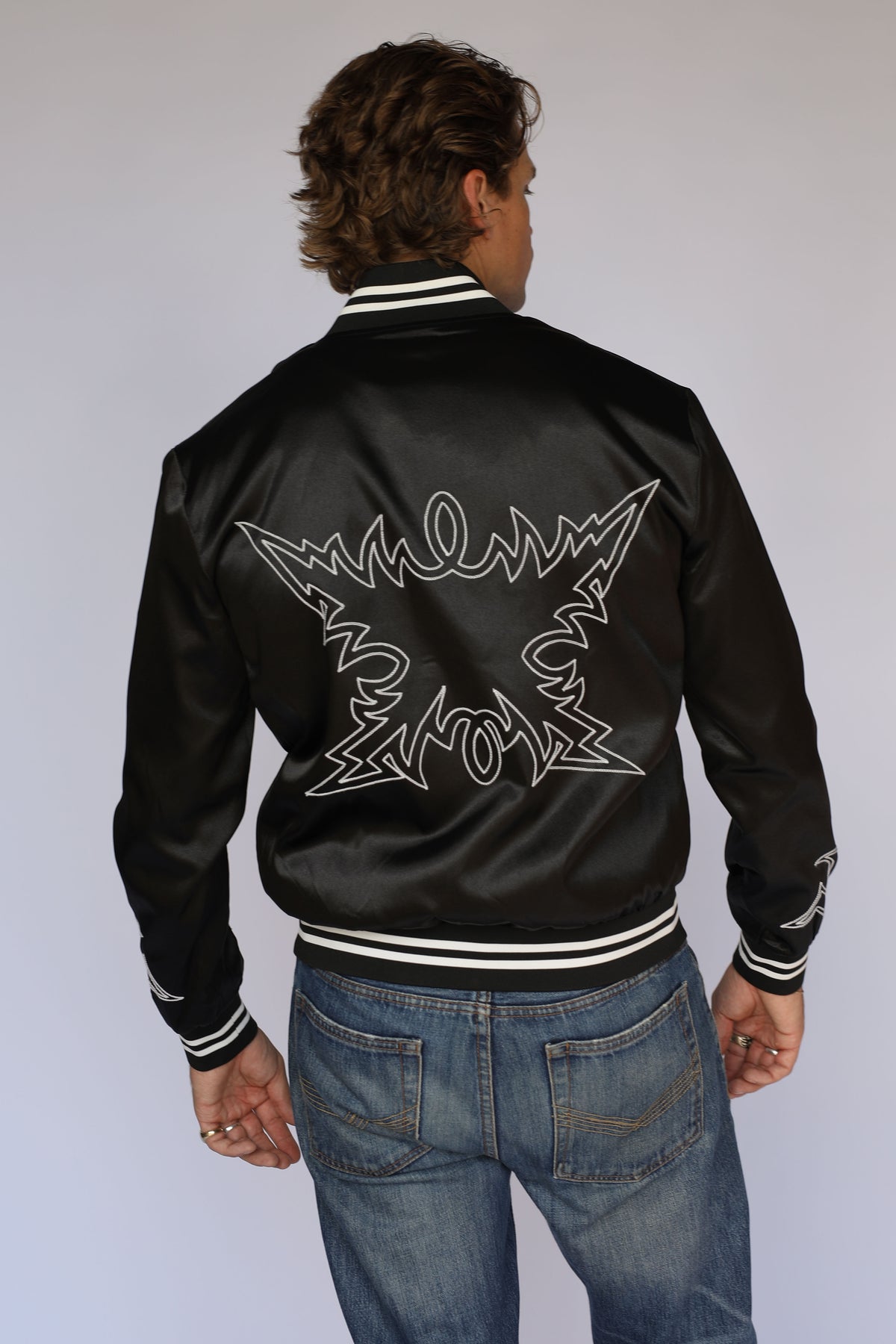 Full back view of the H Bar C Odessa black tour jacket with embroidered back and striped ribbed waistband, vintage inspired western wear.