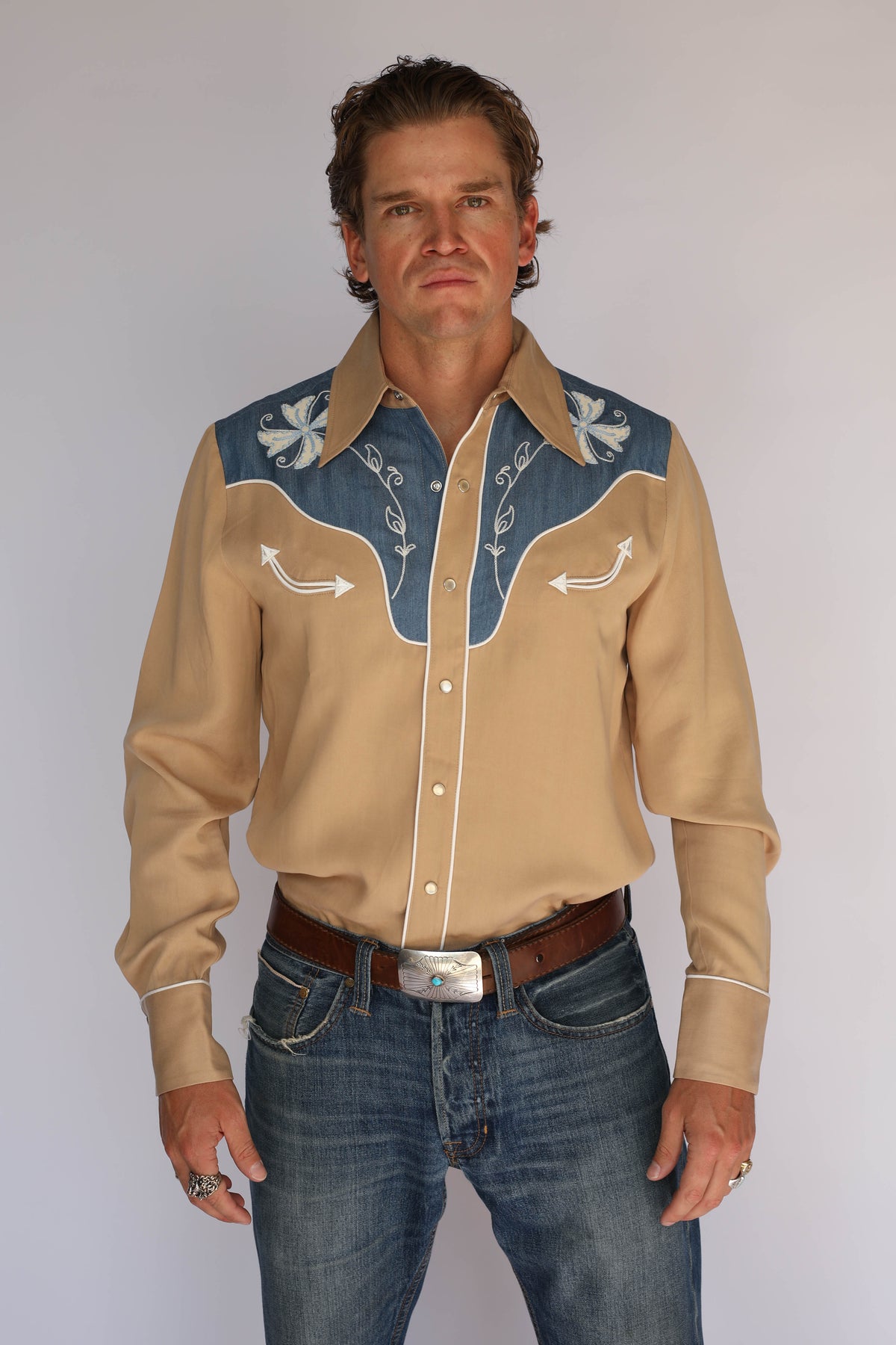 Front view of the H Bar C Telluride shirt in tan Tencel with a contrast denim yoke, white piping, and floral and arrow embroidery, vintage western wear.
