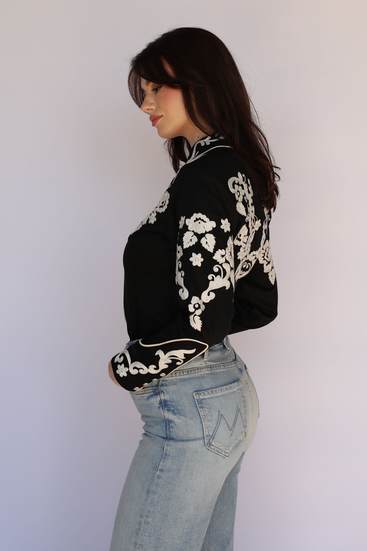 Model posing in the H Bar C Fort Worth black and ivory chain stitch western shirt, vintage inspired western wear.