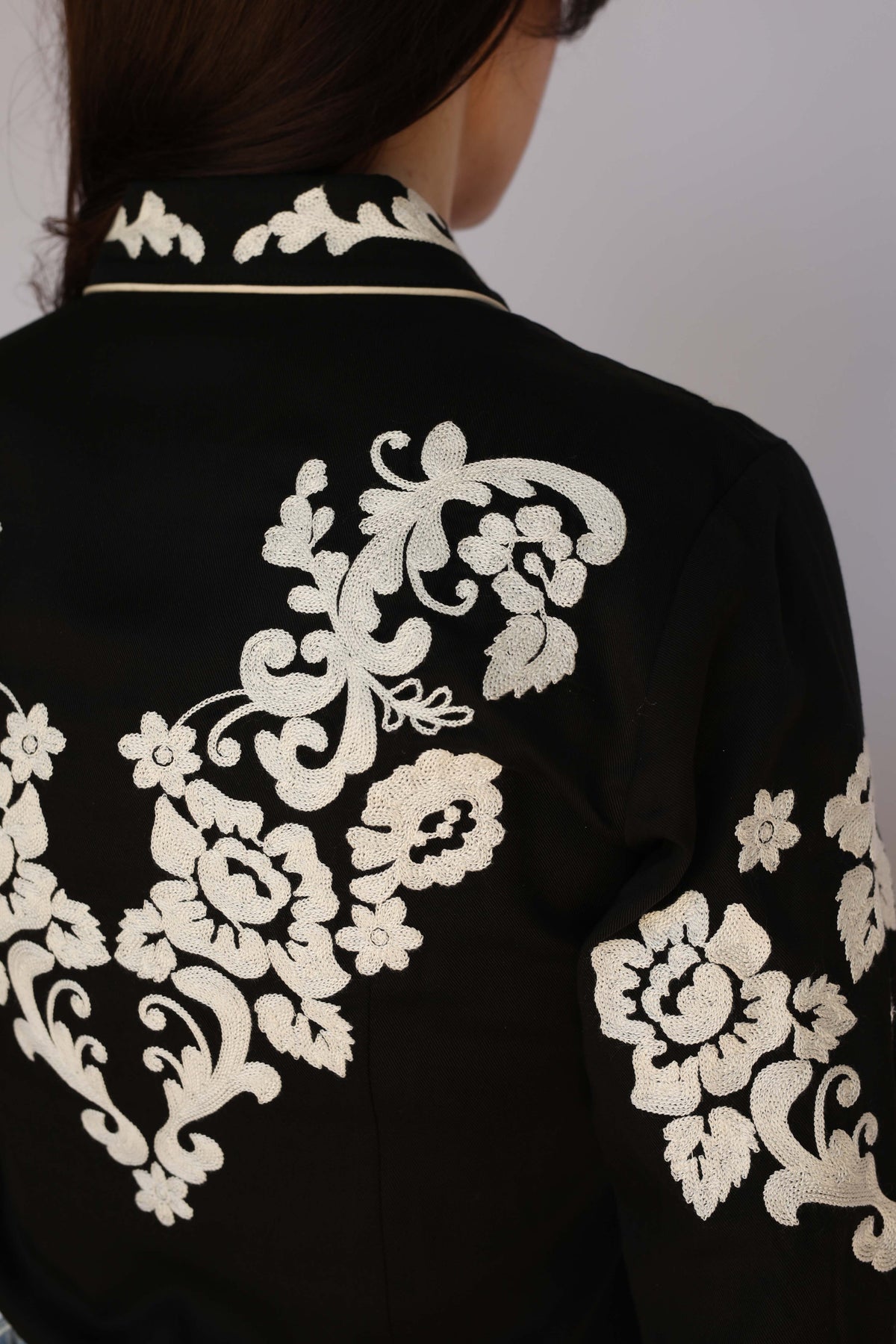 Detail of the ivory chain stitch florals on the back of the H Bar C Fort Worth women's black shirt, vintage inspired western wear.