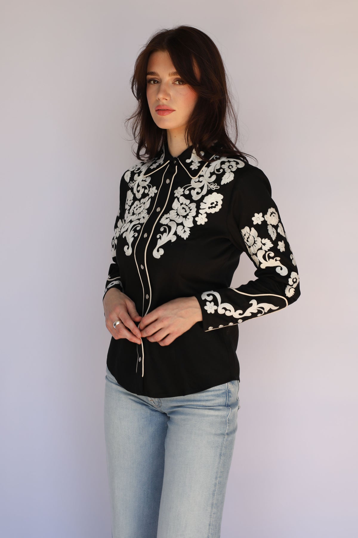 Full length view of the H Bar C Fort Worth black embroidered western shirt worn with light jeans, vintage western wear for women.