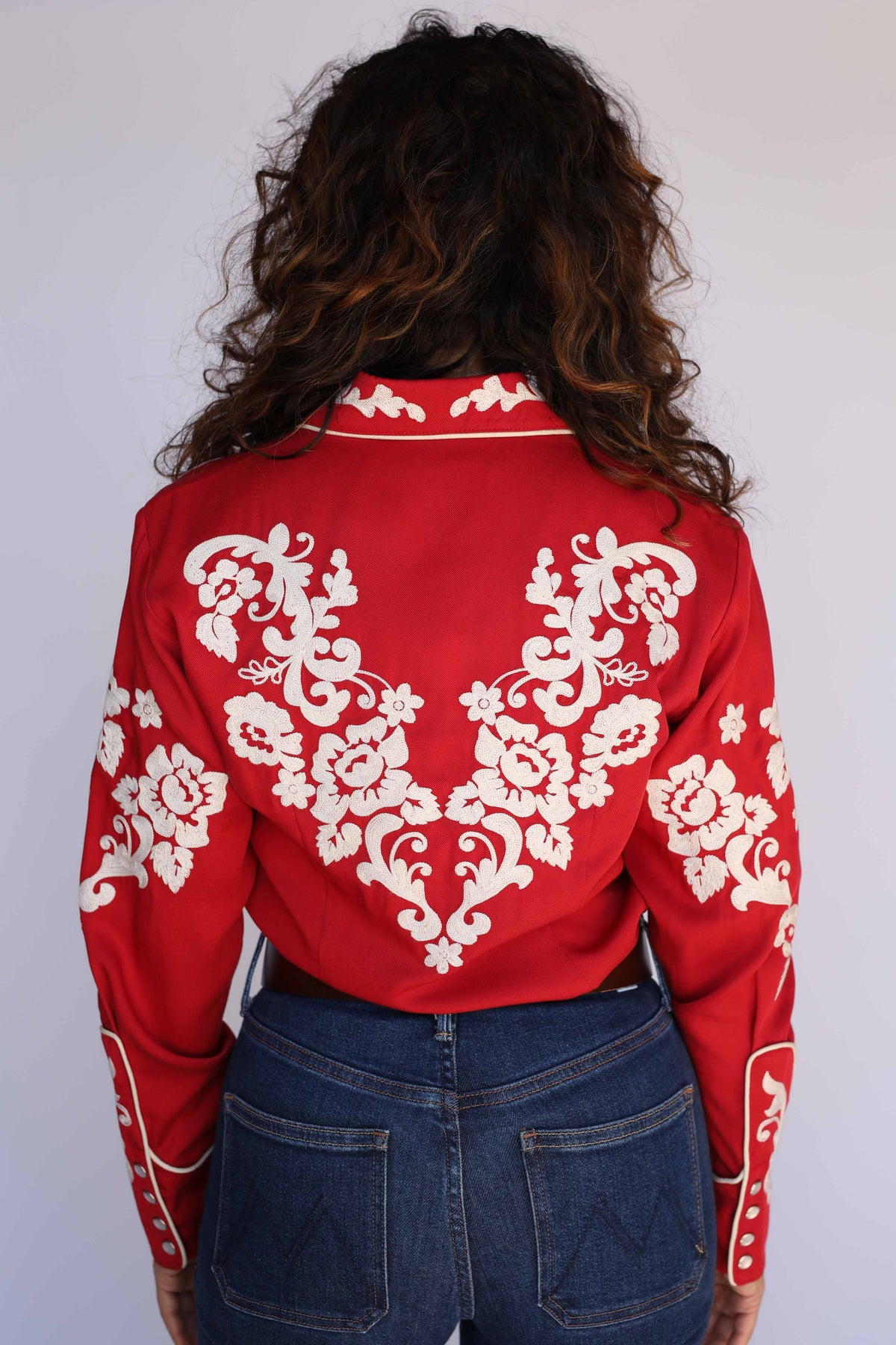 Back view of the H Bar C Fort Worth women's red shirt with mirrored cream floral chain stitch across the back, embroidered collar, and piped snap cuffs, vintage inspired western wear.
