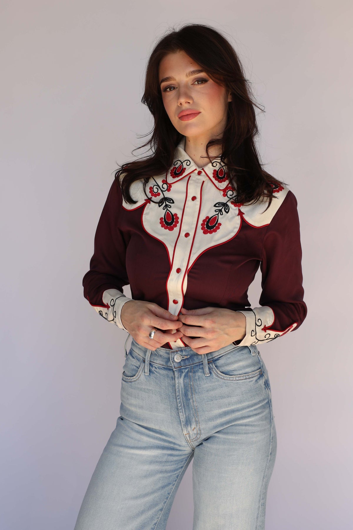 Woman wearing the H Bar C San Jose burgundy western shirt with cream embroidered yoke, collar, and cuffs, red piping, and red snaps, vintage western wear.